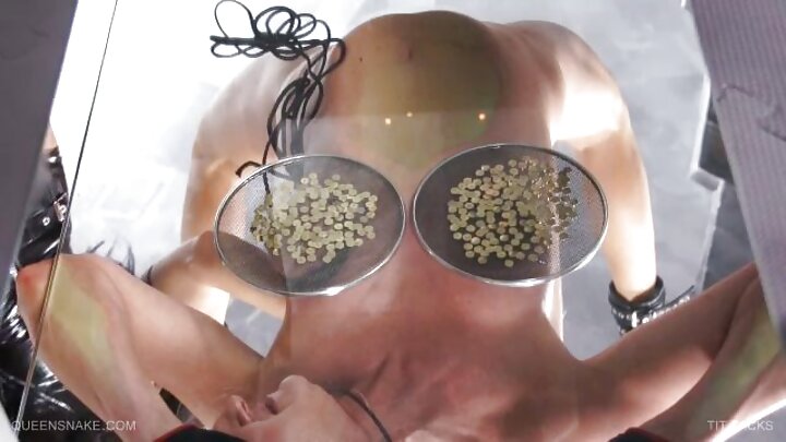 Mwanamume mweusi ananyonya na kumvutwa uume mkubwa mweusi unaotoka kwenye tundu kwenye ukuta wa saluni ya video.